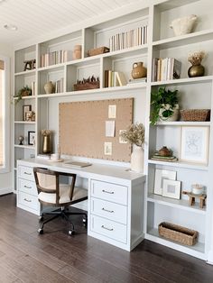 a home office with white bookcases and shelves