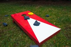 a red and white board game sitting on top of green grass next to black balls