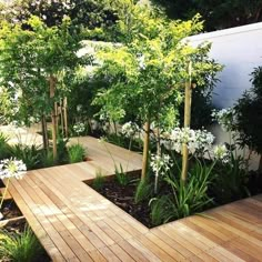 a wooden deck surrounded by white flowers and trees