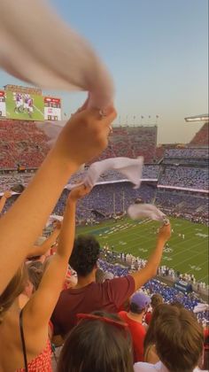 fans at a football game are throwing paper in the air