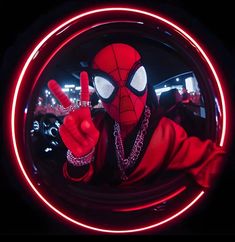 a man dressed as spider - man making the peace sign with his hand in front of him