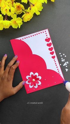 someone is making a valentine's day card out of paper