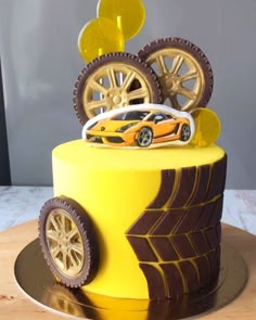 a yellow cake decorated with wheels and cars