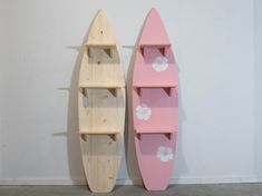 two surfboards are next to each other on the wall and one has a shelf