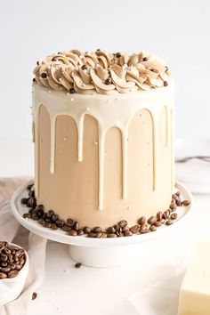 there is a cake that has been decorated with coffee beans on the side and drizzled in white icing