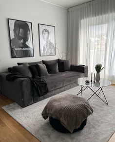 a living room filled with furniture and pictures on the wall next to a large window