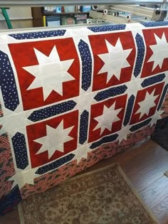 a red, white and blue quilt with stars on it