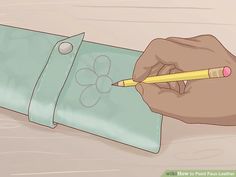 a hand holding a pencil and writing on a piece of paper with a flower drawn on it