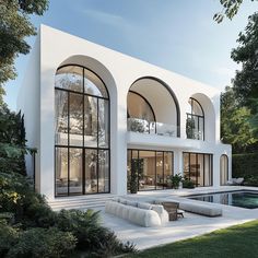 a large white house with arched windows next to a swimming pool