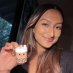 a woman holding a cup with a smiley face on it