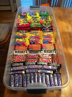 a plastic container filled with candy on top of a wooden table