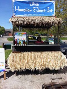 a food cart with some drinks on it and a sign that says hawaiian shave ice