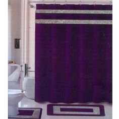 a bathroom with a purple shower curtain and matching rugs