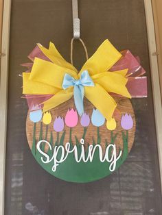 a door hanger that says spring with tulips