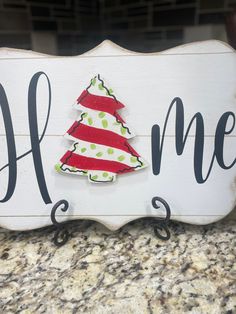 a wooden sign that says home with a christmas tree on it