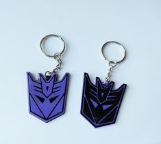 two key chains with the shape of a robot head