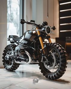 a black and gold motorcycle parked in front of a large glass window on a tiled floor