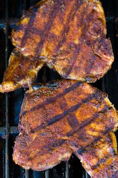 two steaks are cooking on the grill