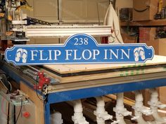 a blue sign that says flip flop inn on top of a table in a shop