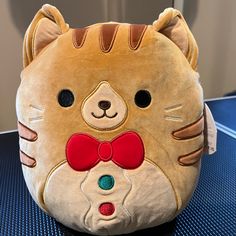 a stuffed animal with a red bow on it's head sitting on a table