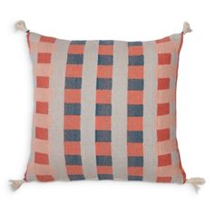 an orange and blue striped pillow with tassels on the edges, sitting on a white background