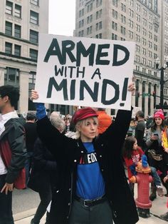 a person holding up a sign that says armed with a mind