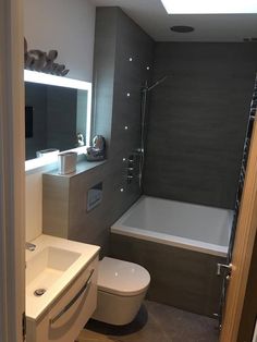 a bathroom with a sink, toilet and bathtub in the corner next to a mirror