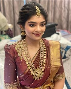 a woman in a maroon and gold sari