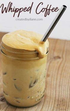 a jar filled with whipped coffee sitting on top of a wooden table