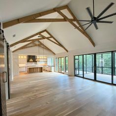 an empty room with wood floors and large windows