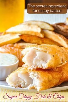 a close up of a plate of food with fish and chips