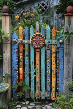 a colorful wooden gate is surrounded by plants and flowers