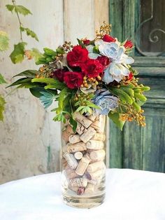 a vase filled with lots of flowers and wine corks on top of a table