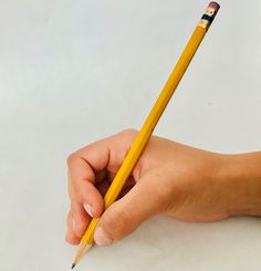 a person holding a pencil in their hand