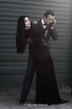 two people dressed in black and white posing for the camera with their arms around each other