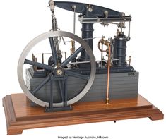 a model of a steam engine on a wooden stand with metal pipes and gauges