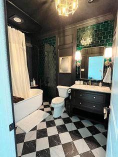 a bathroom with black and white checkered flooring on the walls, tub, sink, toilet and shower