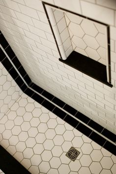 a bathroom with black and white tiles on the floor