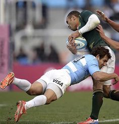 two rugby players colliding for the ball during a game against eachother