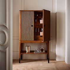 an old fashioned bar cabinet in the corner of a room