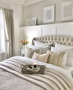 a bed with white sheets and pillows in a bedroom next to two pictures on the wall