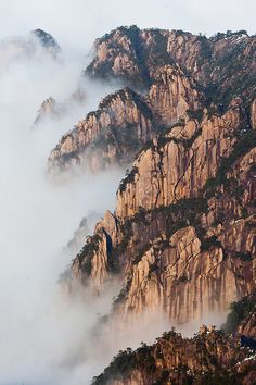 the mountains are covered in fog and low clouds