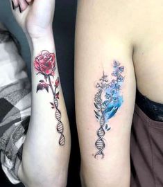 two people with tattoos on their arms and one is holding a flower in the other hand