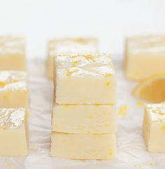 several pieces of white cake sitting on top of a table next to slices of lemon