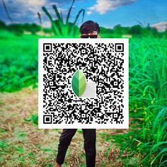 a man holding up a qr - code with a green leaf on it's face