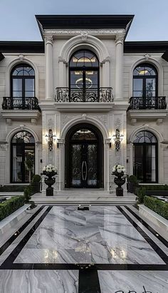 a large white house with black and white trim on the front door, windows and balconies