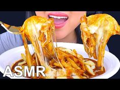 a woman is eating some food out of a bowl with her mouth open and the words asmr on it