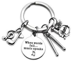 a keychain with musical instruments on it and the words when words fail, music speaks