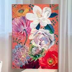 a painting of flowers on an orange and pink background is displayed in front of a window