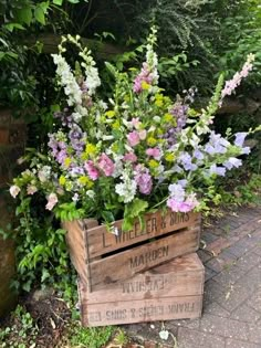 a wooden crate filled with lots of flowers